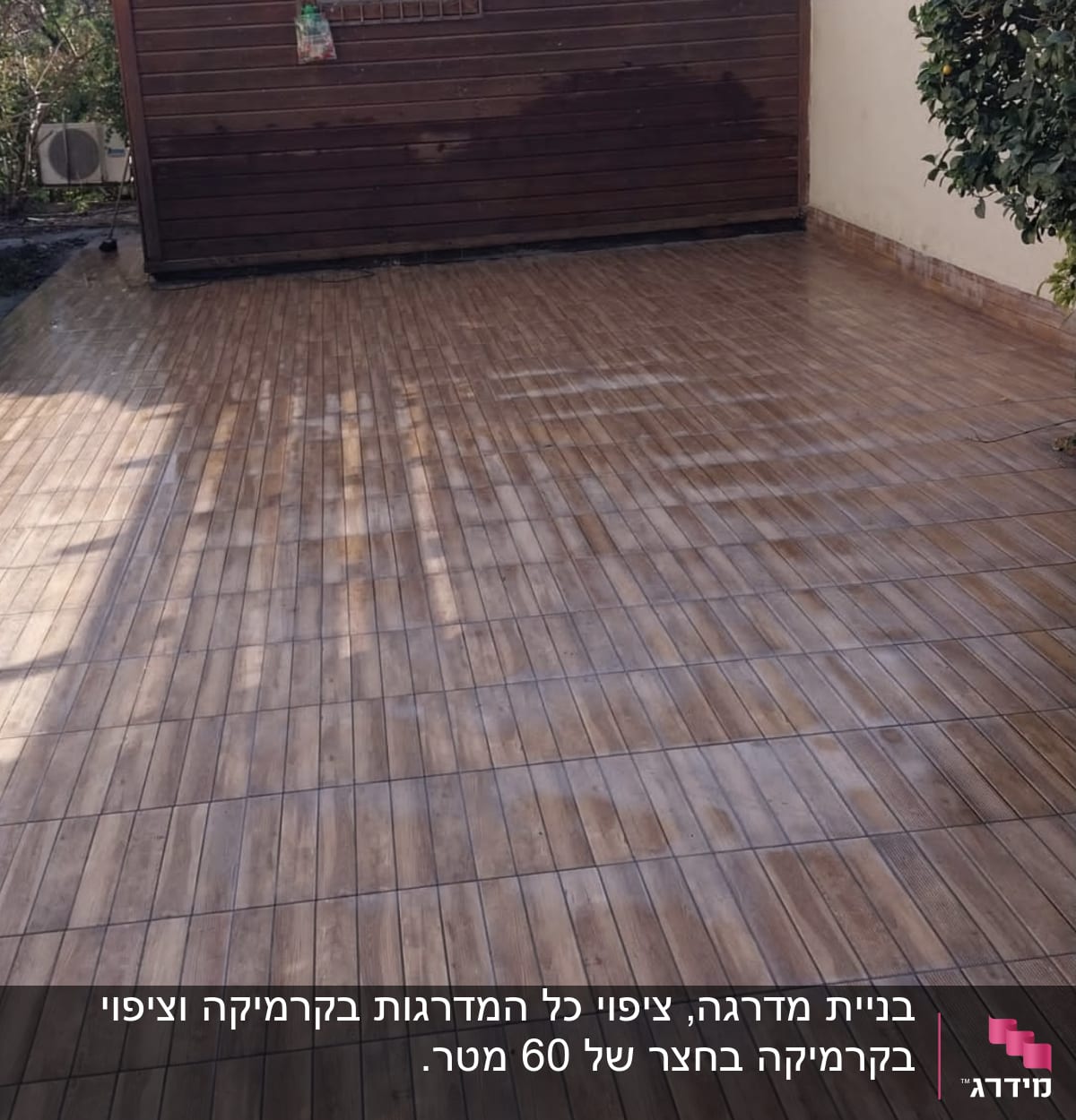 ריצוף עץ חדש בחצר ליד מבנה עץ